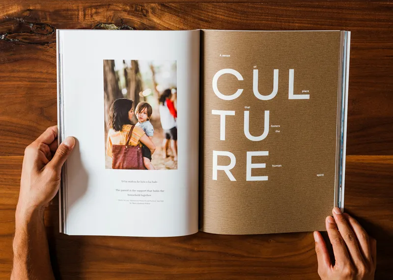 Open magazine on a wooden table, displaying colorful graphics and text that emphasize cultural discussions and insights.